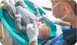 Team member working on a baby's smile