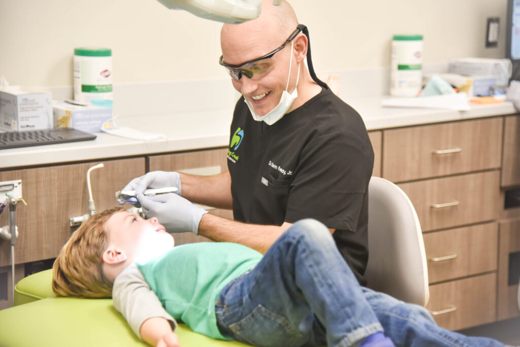 Dentist performing an exam on smiling patient.
