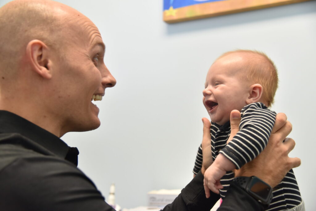 Dr Kennedy laughing with an infant child.