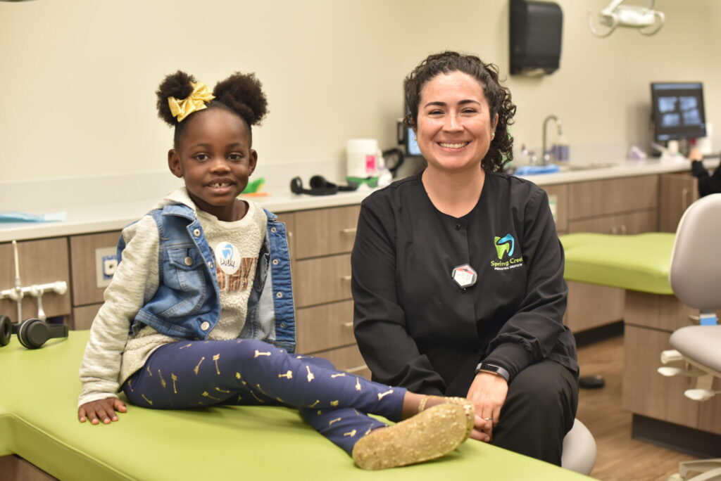 Spring Creek team member with a patient both smiling at the camera.